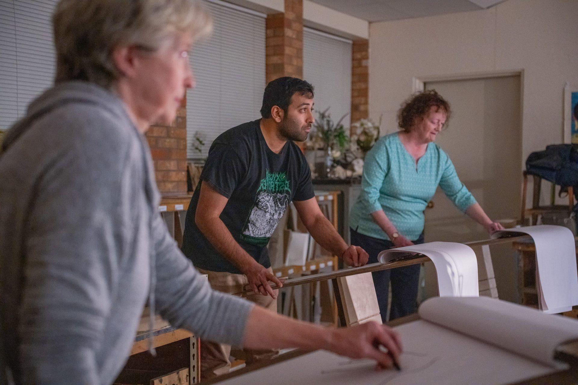 Adults in a printmaking workshop class.